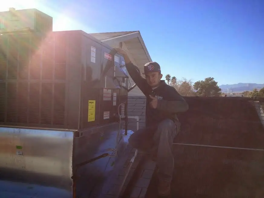 HVAC technician performing Heat Pump Repair on a rooftop unit in Weldon Spring
